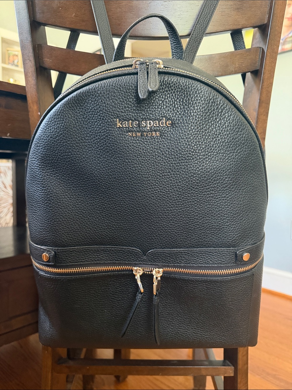 Kate Spade black pebbled leather backpack with gold hardware.